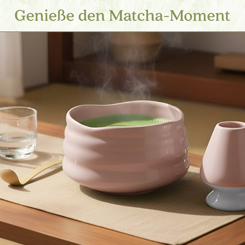 Gewurzladen Nafels Dampfender grüner Matcha-Tee in einer rosa Schale neben Besenhalter und Löffel.