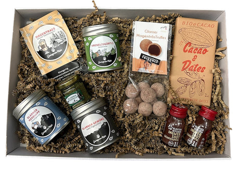 Gewurzladen Nafels Geschenkbox gefüllt mit Glarnermagentrüffel, Gewürzen, Pulvern und einer Cacao & Dates Schokoladentafel.